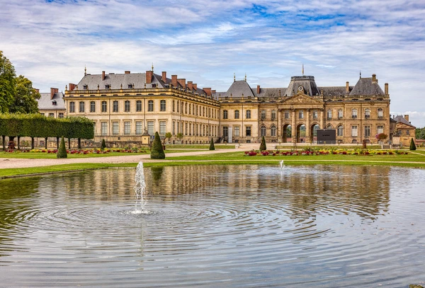 Photographie réaliste montrant une maison résidentielle typique de la région Meurthe-et-Moselle avec sa toiture en tuiles ou ardoises intacte et bien entretenue. La façade et la toiture doivent être clairement visibles sous un bon éclairage naturel. L'image doit transmettre confiance et professionnalisme, représentant le type d'habitation que LRI Couverture rénove ou entretient. Perspective vue de l'extérieur, maison de qualité, environnement résidentiel calme et soigné.